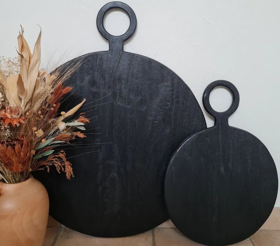 planches rondes noir avec des fleurs séchés