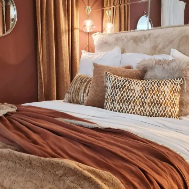 lit avec plusieurs coussins et parure couleur terracotta