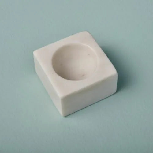 Coquetier en marbre blanc sur fond bleu