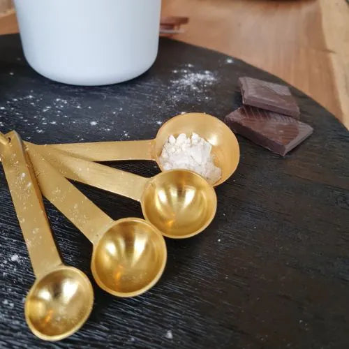 quatre doseuses sur une planche noir avec du chocolat et du sel