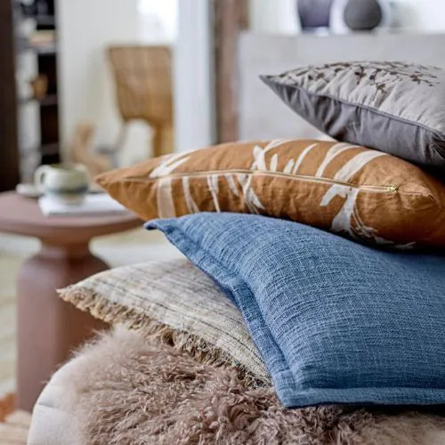 quatre coussins en coton bleu, marron, beige et gris