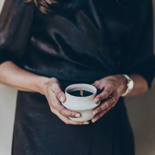 femme tenant une bougie blanche et intérieure noir