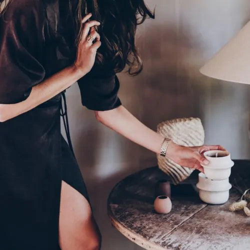 femme tenant une petite bougie d'intérieure blanche