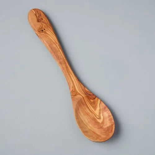 longue cuillère en bois d'olivier sur fond gris