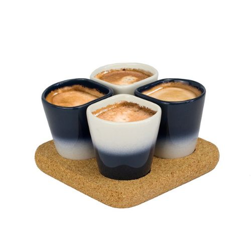 quatre tasses à café rempli sur un dessous de plat en liège