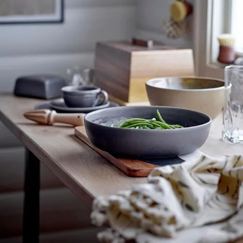 serviette de cuisine posé sur à table à côté d'une assiette de haricot