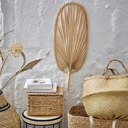 éventail pour décoration murale sur un mur en béton blanc