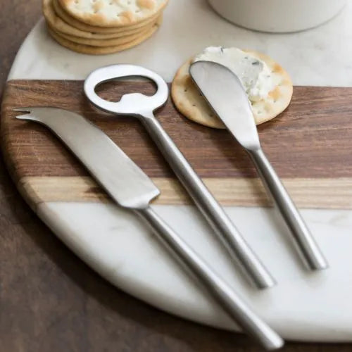 planche ronde en marbre blanc et bois avec des couverts en inox dessus
