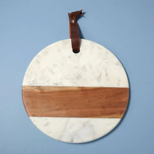 planche ronde en marbre blanc et bois avec une lanière sur fond bleu