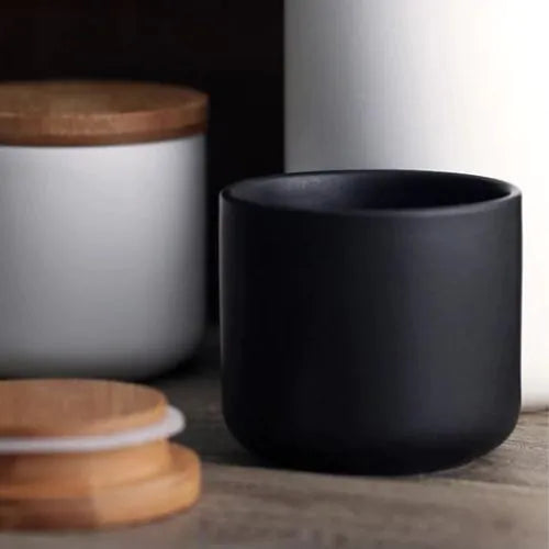 plusieurs pots en grès blanc et noir avec leurs couvercles fermé et ouvert