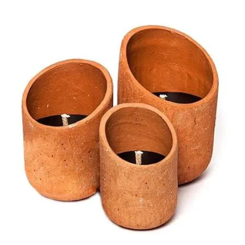 trois bougies d'extérieure orange en céramique sur fond blanc