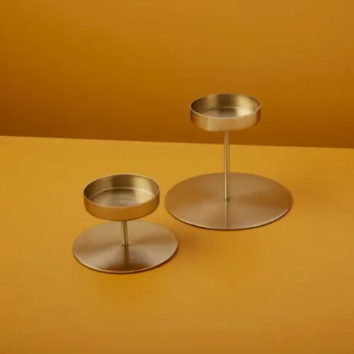 bougeoirs dorés petit et moyen sur fond jaune