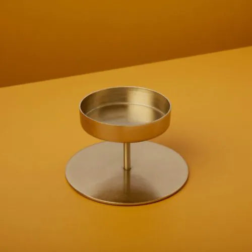 petit bougeoir doré sur fond jaune