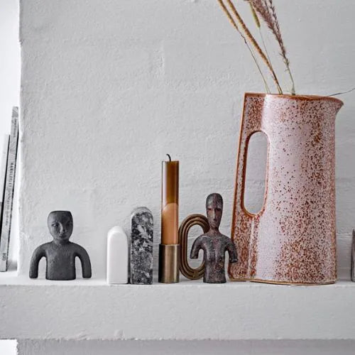 bougie marron dégradé sur le haut d'une cheminée à côté d'un vase
