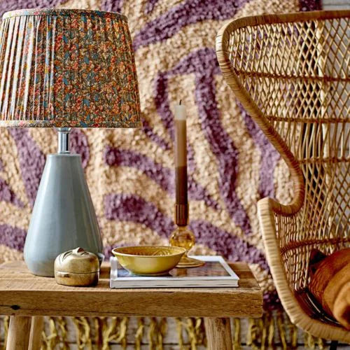 bougie marron dégradé sur une table basse à côté d'une lampe