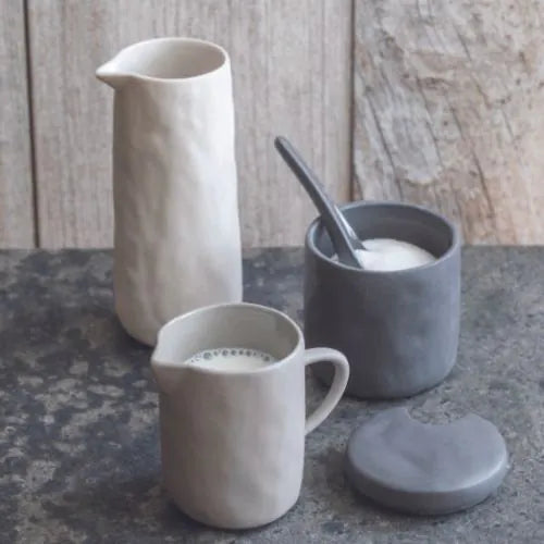 deux pichets en grès blanc sur une table effet béton