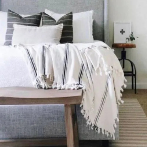 plaid blanc avec rayure bleu sur un lit