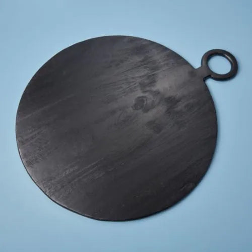 grande planche à découper ronde noire sur fond bleu
