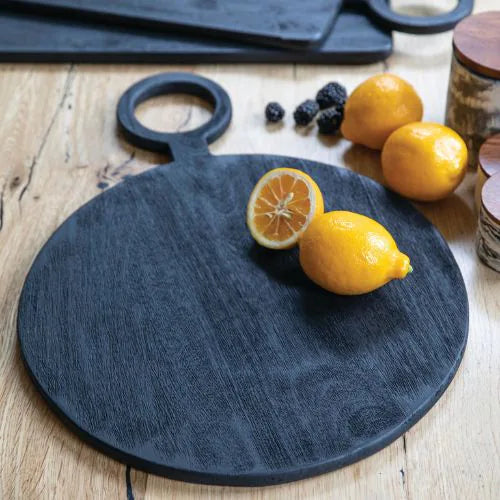 planche à découper ronde noire avec un citron coupé