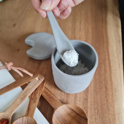 Récipient à condiments en grès ouvert avec une cuillère qui montre son contenant