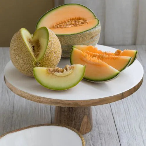 plat de présentation en bois de manguier avec des melons coupés dessus