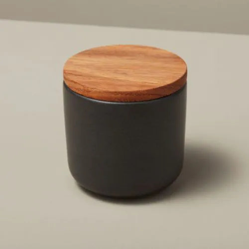 petit pot en grès noir avec son couvercle en bois d'acacia sur fond beige