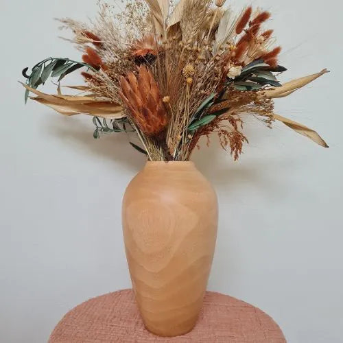 vase en bois de manguier avec des fleurs séchées sur une petit table de couleur